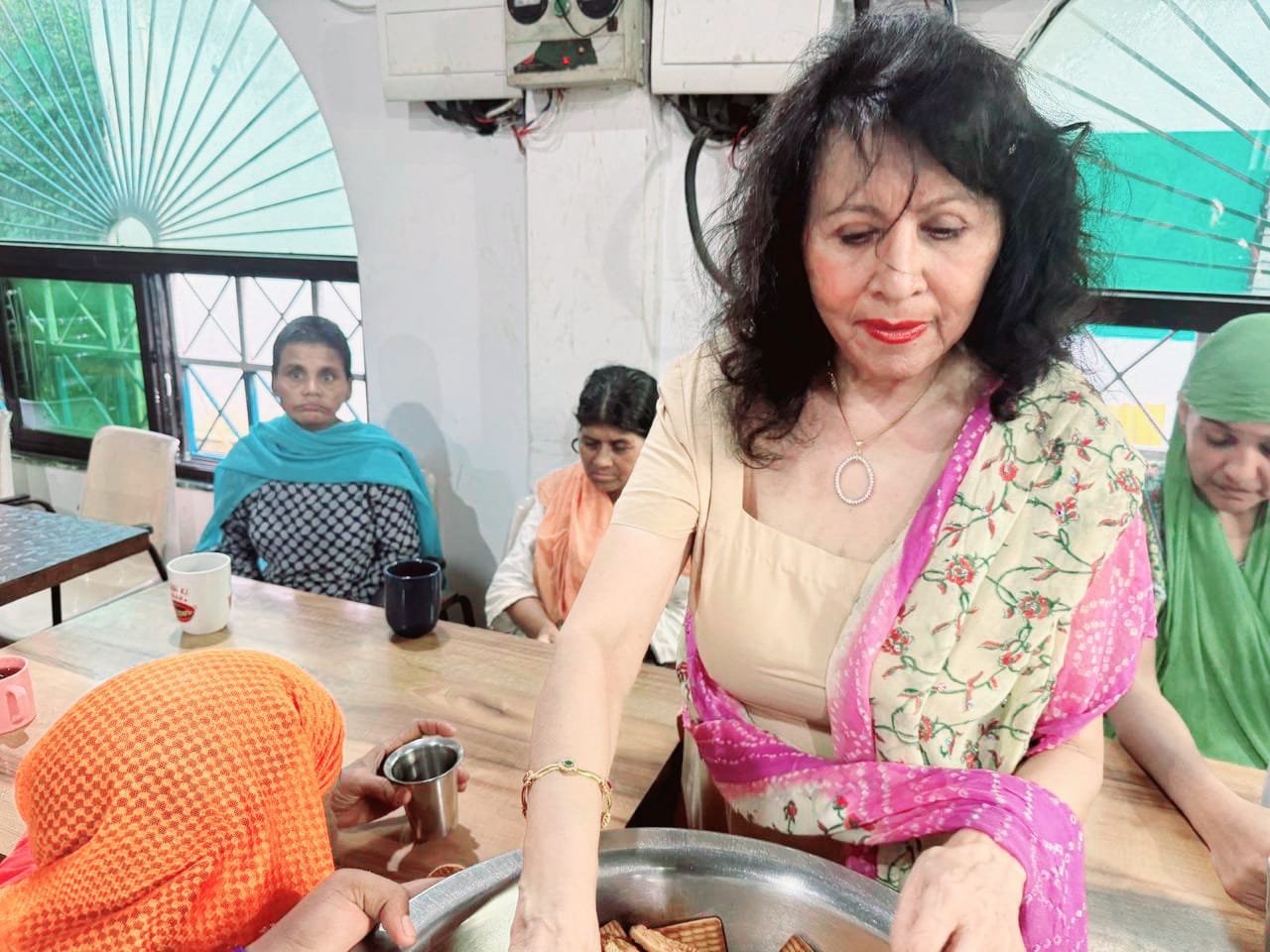 Kadambari serving biscuits at a community outreach event