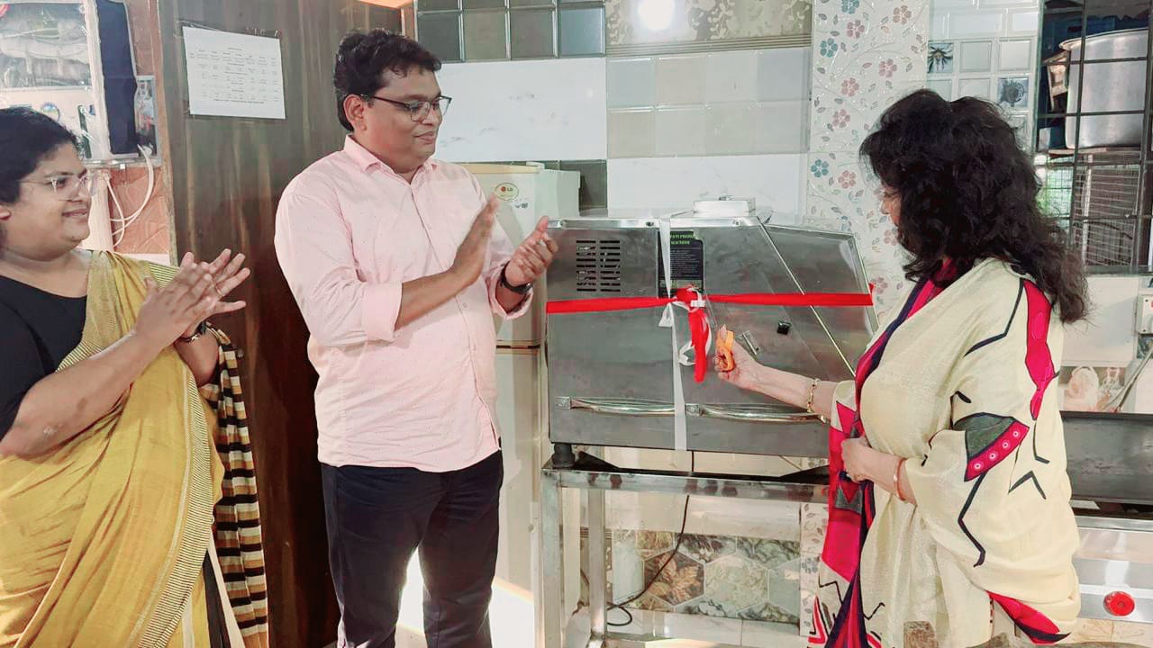 Kadambari at a ribbon-cutting ceremony for a charity kitchen appliance